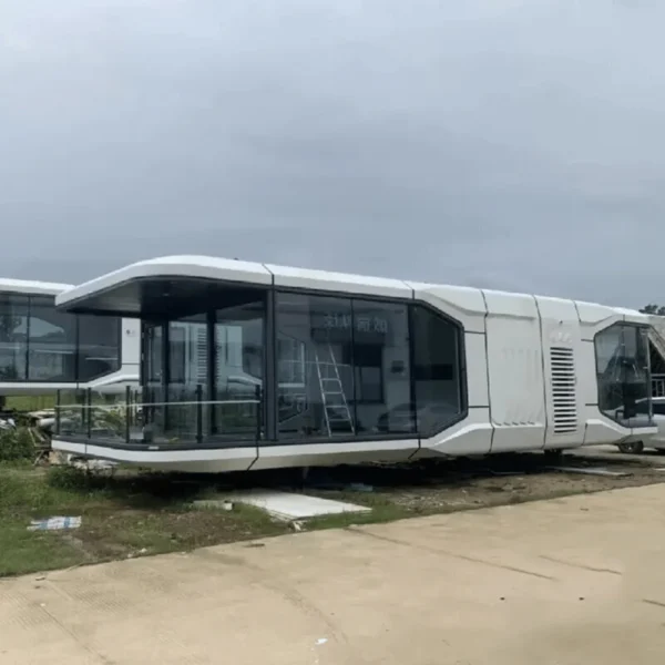 Side view of the Space Cabin K70 38m² modular villa, featuring an extended futuristic design with a large covered balcony and floor-to-ceiling glass walls.